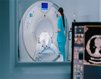 Nurse send patient to MRI capsule on moving table. Magnetic resonance imaging of brain. Room of examinaning with medical equipment.